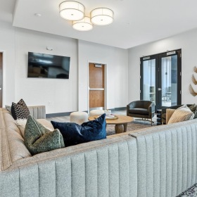 a lounge room with a couch and a tv and glass doors
