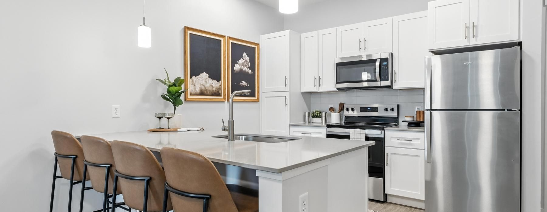 a kitchen with white cabinets and a breakfast bar with stools